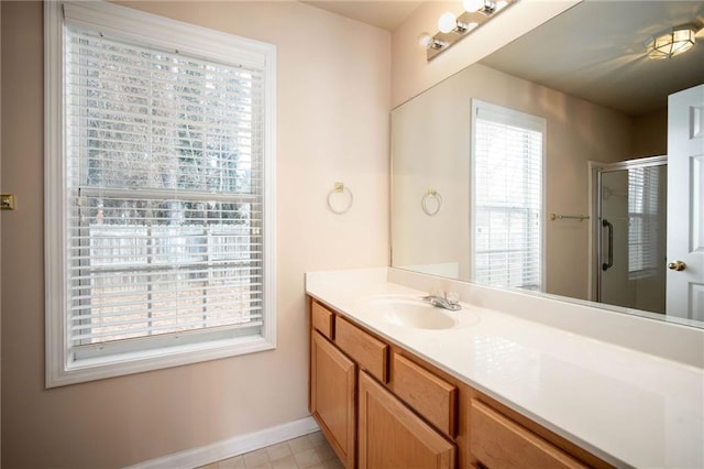 bathroom featuring a shower with door and vanity