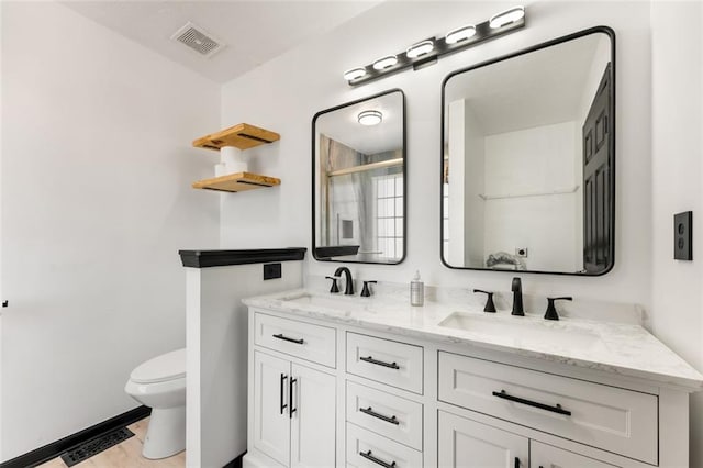 full bath with toilet, visible vents, and a sink