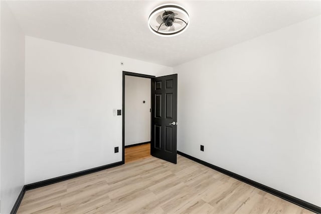 empty room featuring light wood-style floors and baseboards