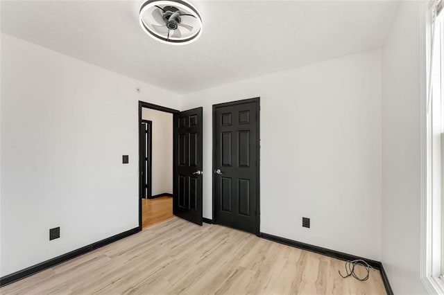 empty room featuring light wood-style floors and baseboards