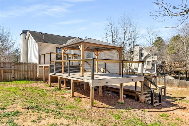 back of house with a gazebo, a fenced backyard, and a wooden deck