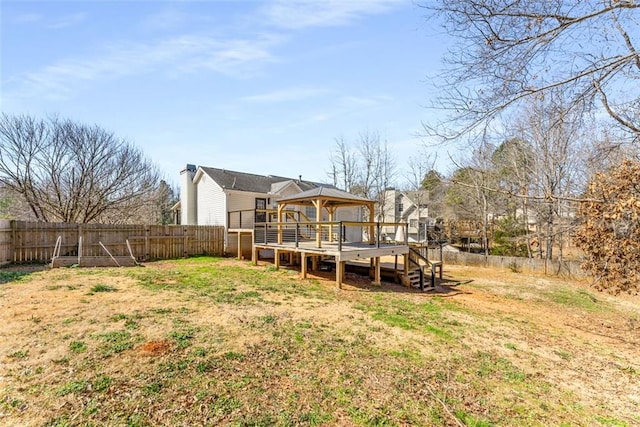 back of property with a fenced backyard and a deck