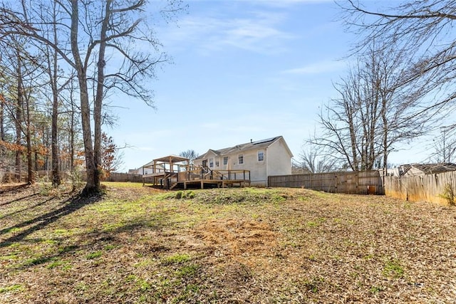 rear view of property with a fenced backyard and a deck