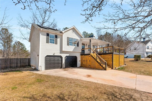 view of front of property featuring solar panels, concrete driveway, stairway, an attached garage, and a front yard