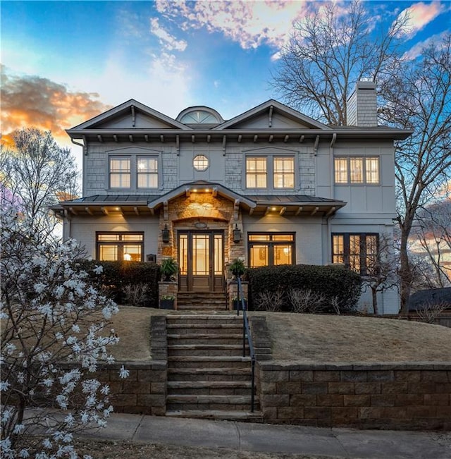 view of front of house featuring stone siding and a chimney