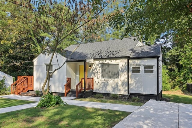 view of front of house with a garage and a front lawn