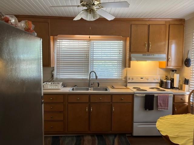 kitchen featuring stainless steel fridge, ceiling fan, sink, and white range with electric cooktop