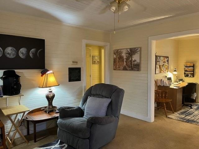 sitting room featuring ceiling fan, crown molding, and carpet