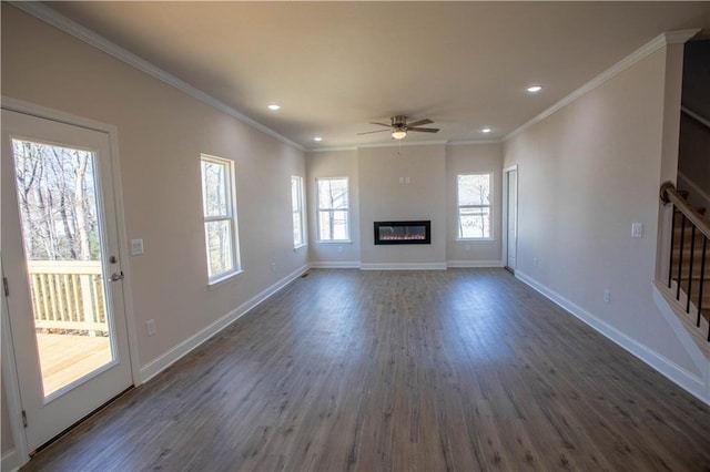 unfurnished living room with a ceiling fan, baseboards, ornamental molding, dark wood-style floors, and a glass covered fireplace