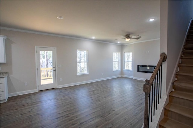 unfurnished living room featuring stairs, baseboards, dark wood finished floors, and crown molding