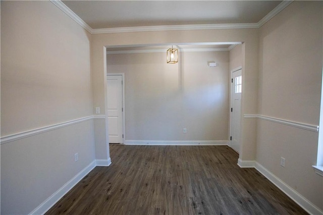 empty room with crown molding, baseboards, and wood finished floors