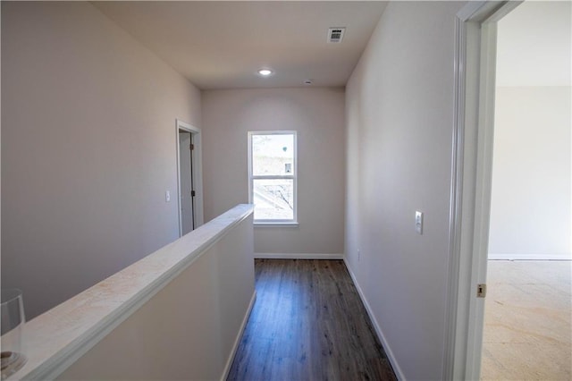 hallway featuring baseboards, visible vents, wood finished floors, an upstairs landing, and recessed lighting