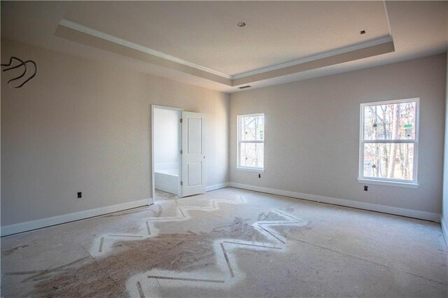 unfurnished room with baseboards, a raised ceiling, and ornamental molding