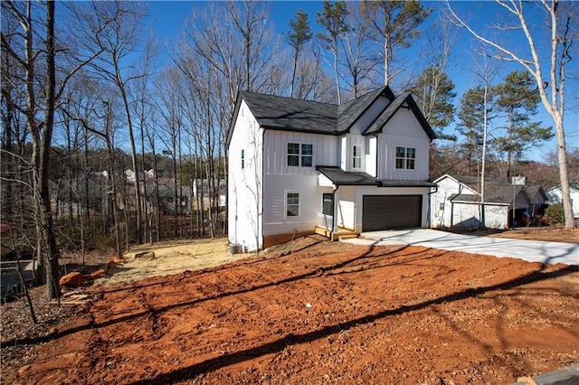 modern farmhouse featuring a garage, concrete driveway, and board and batten siding