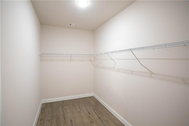 walk in closet featuring visible vents and wood finished floors