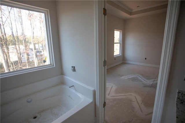 bathroom featuring baseboards and a bath