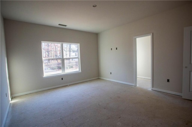 carpeted spare room with visible vents and baseboards