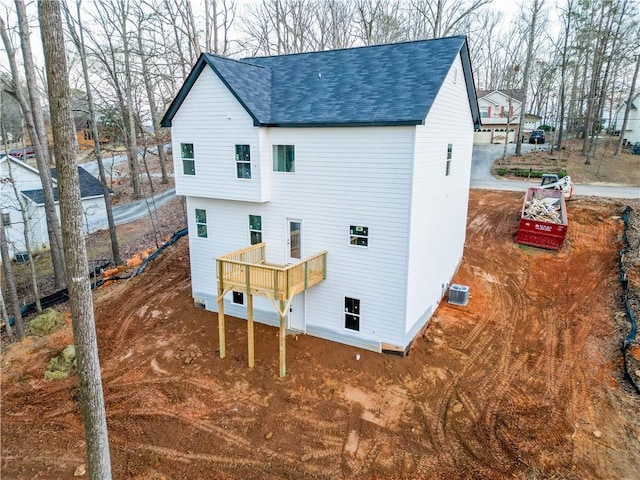 back of property with a wooden deck and central AC