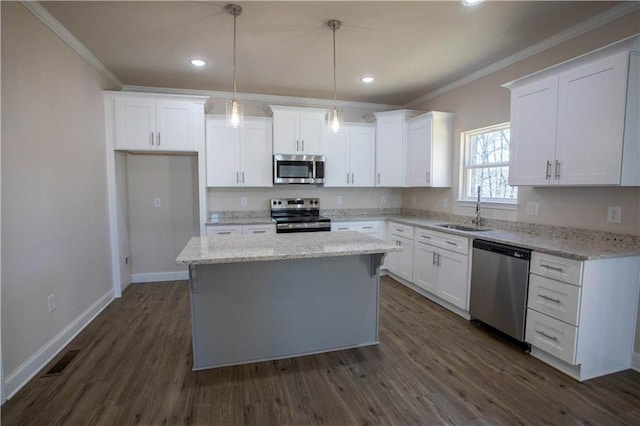 kitchen featuring appliances with stainless steel finishes, white cabinetry, a sink, and ornamental molding