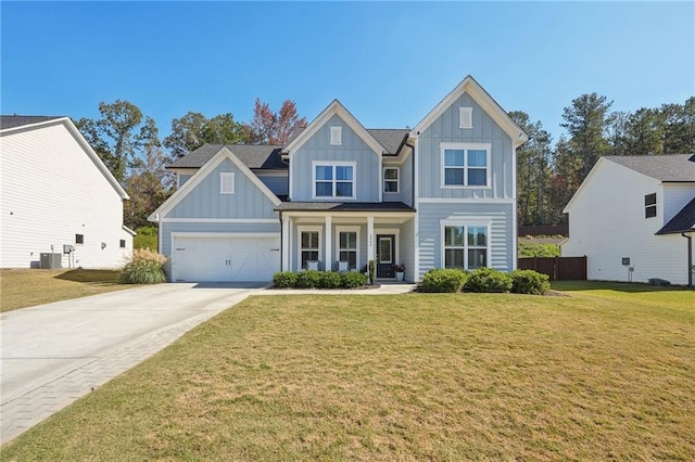 craftsman inspired home with cooling unit, a front yard, covered porch, and a garage