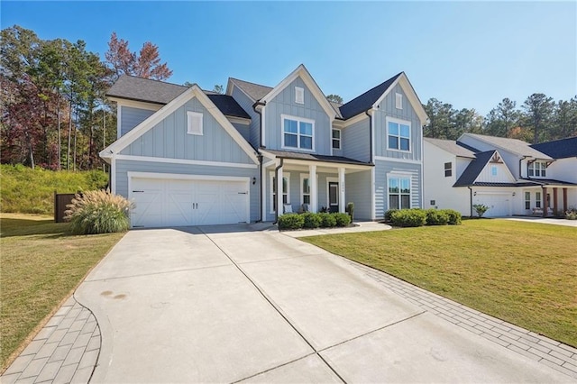 view of front of home featuring a front yard, covered porch, and a garage