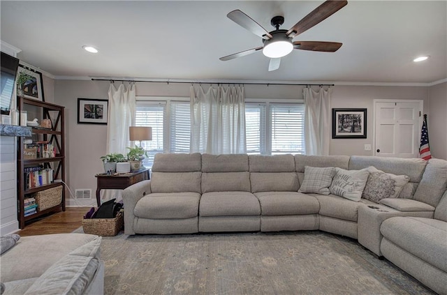 living room featuring visible vents, plenty of natural light, wood finished floors, and crown molding