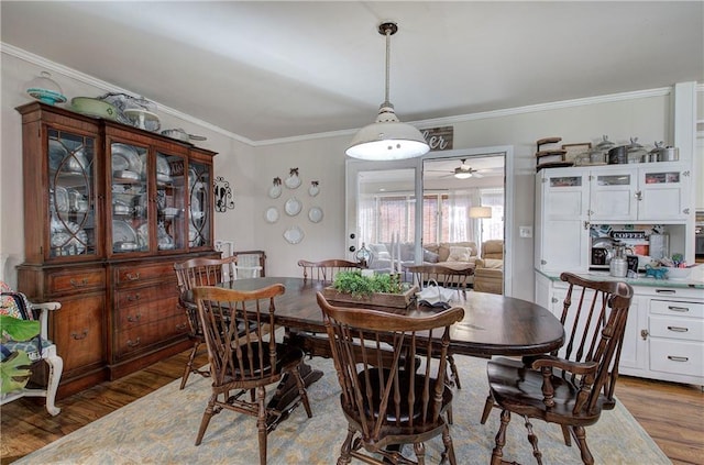 dining space with crown molding and wood finished floors