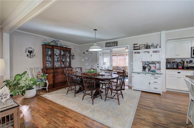 dining room with crown molding and wood finished floors