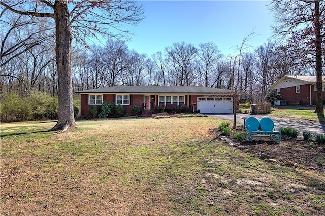 ranch-style house with a front lawn, brick siding, a garage, and driveway