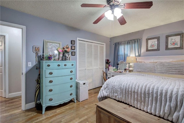 bedroom featuring a ceiling fan, a closet, light wood finished floors, and a textured ceiling