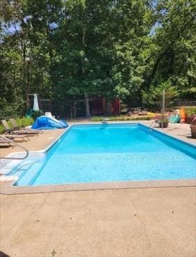 outdoor pool with a patio area and fence