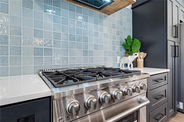 kitchen featuring backsplash, high end stainless steel range, and gray cabinetry