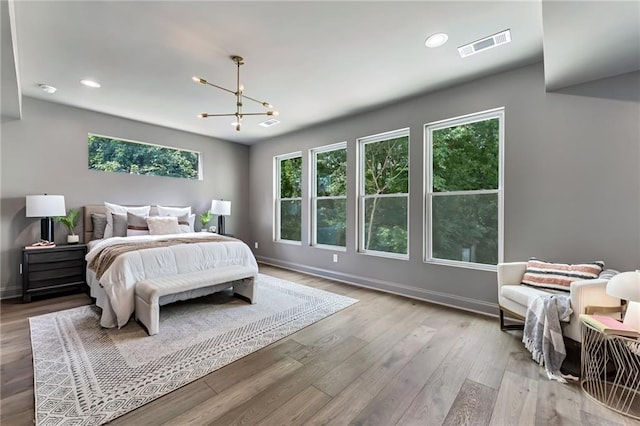 bedroom with a chandelier and light hardwood / wood-style floors