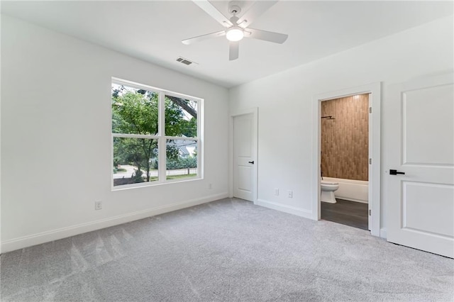 unfurnished bedroom with ensuite bath, ceiling fan, and light colored carpet