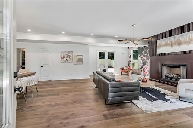 living room featuring wood-type flooring, an inviting chandelier, and french doors