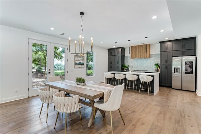 dining area featuring a chandelier, french doors, and light hardwood / wood-style floors