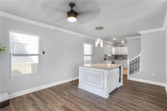 kitchen featuring dark wood-type flooring, ceiling fan with notable chandelier, a sink, white cabinets, and baseboards