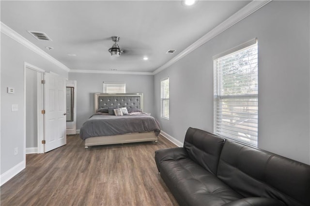 bedroom featuring visible vents, baseboards, wood finished floors, and ornamental molding