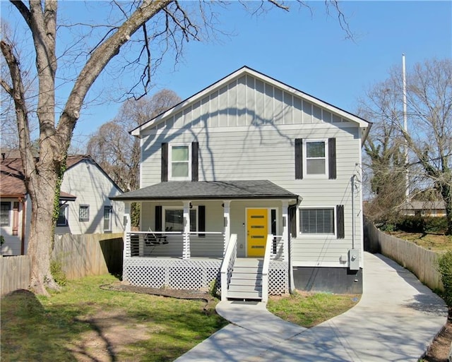 view of front of house featuring board and batten siding, fence, covered porch, and driveway