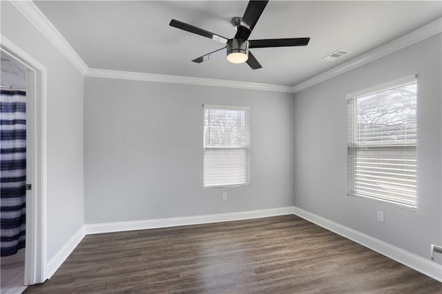 spare room with visible vents, dark wood finished floors, and ornamental molding