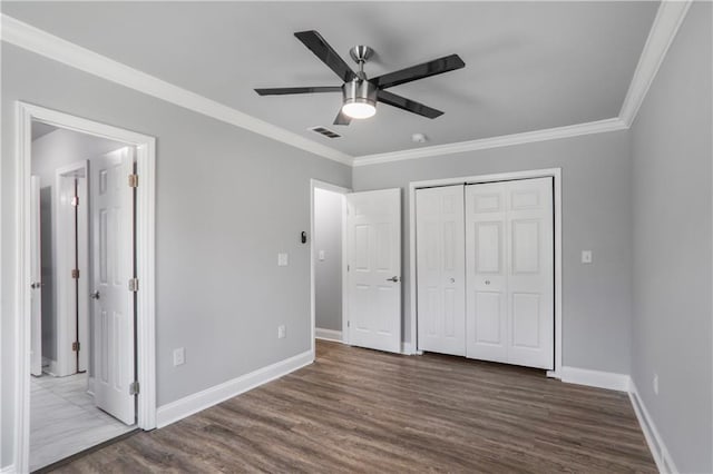 unfurnished bedroom featuring wood finished floors, baseboards, visible vents, and ornamental molding