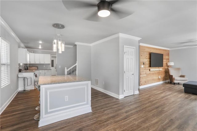 kitchen with visible vents, dark wood-type flooring, a ceiling fan, white cabinetry, and crown molding