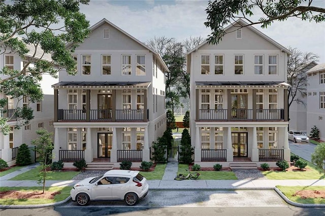 view of front of property featuring covered porch, french doors, and a balcony