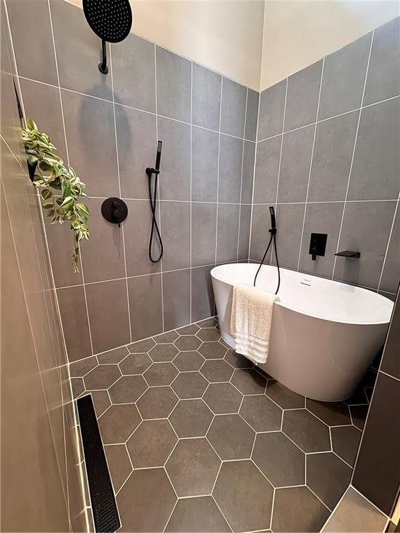 1400 Peter Haughton Way NW, Atlanta, GA 30318 - bathroom featuring tile walls, a tile shower, and a soaking tub