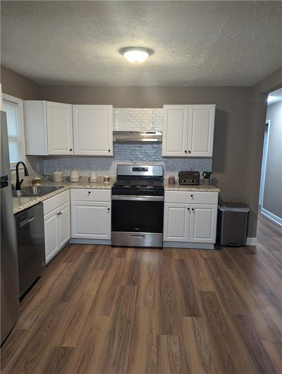 kitchen featuring appliances with stainless steel finishes, sink, white cabinets, and dark hardwood / wood-style floors