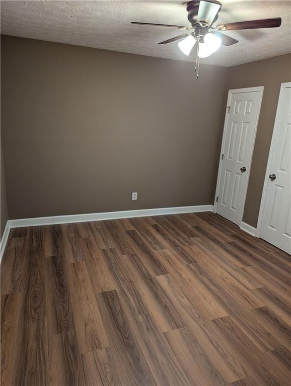 unfurnished bedroom featuring ceiling fan, dark wood-type flooring, and a textured ceiling