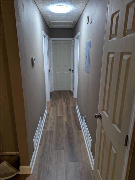 hallway with wood-type flooring and a textured ceiling