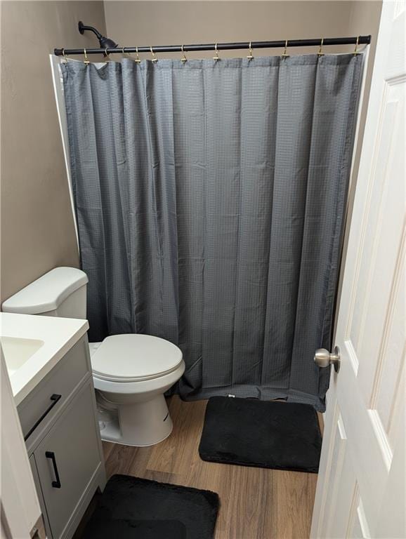 bathroom with vanity, hardwood / wood-style flooring, a shower with curtain, and toilet