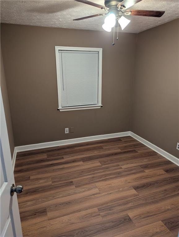 spare room with ceiling fan, dark wood-type flooring, and a textured ceiling