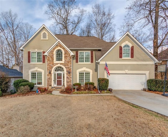 view of property with a garage and a front lawn